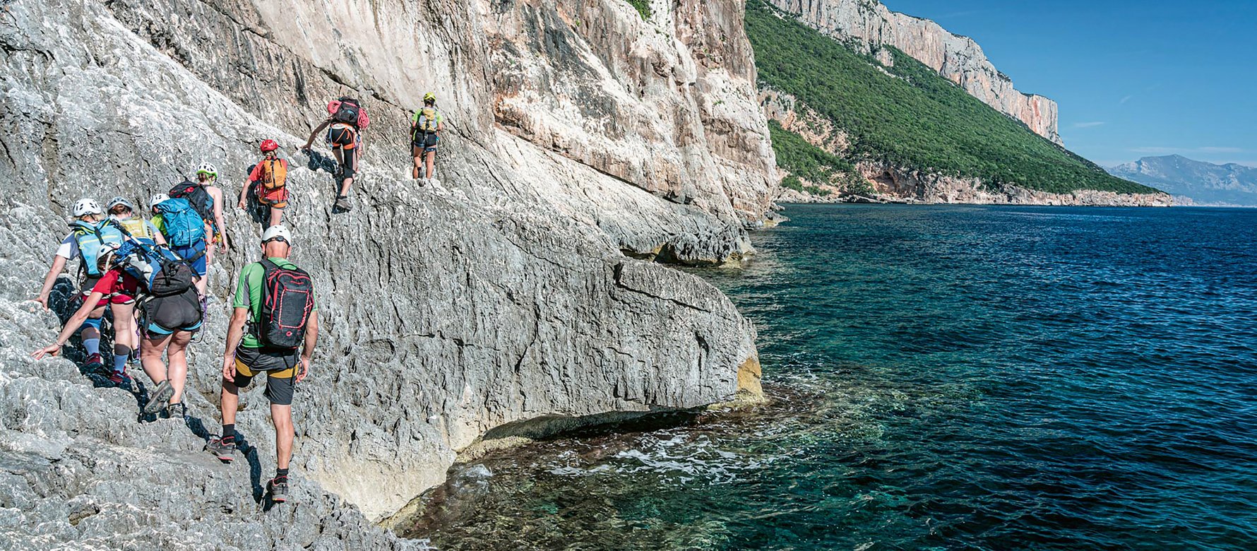 Trekkers in cammino sugli scogli sardi