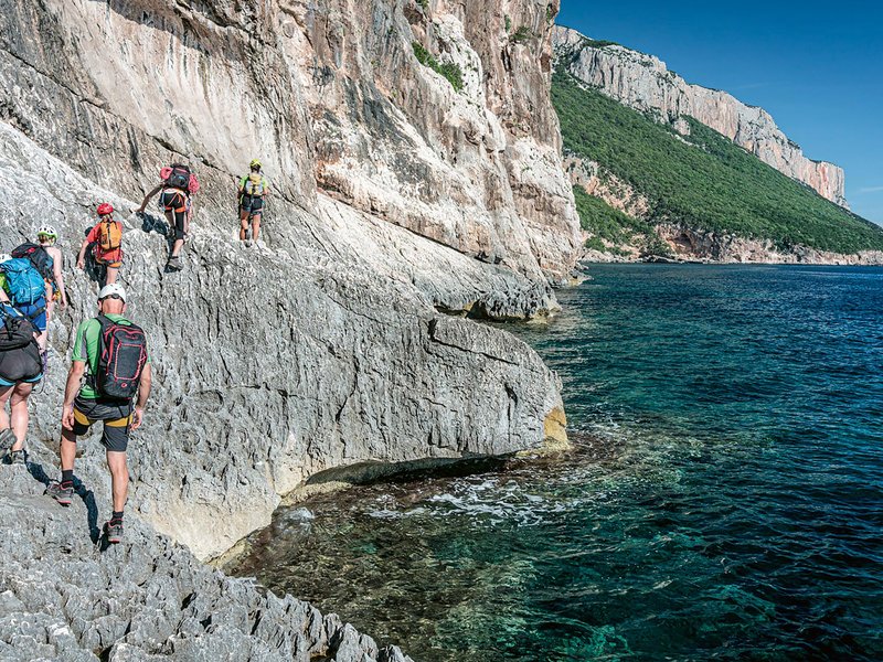 Trekkers in cammino sugli scogli sardi