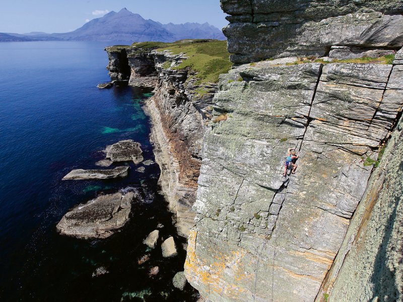 Climber in parete a picco sul mare