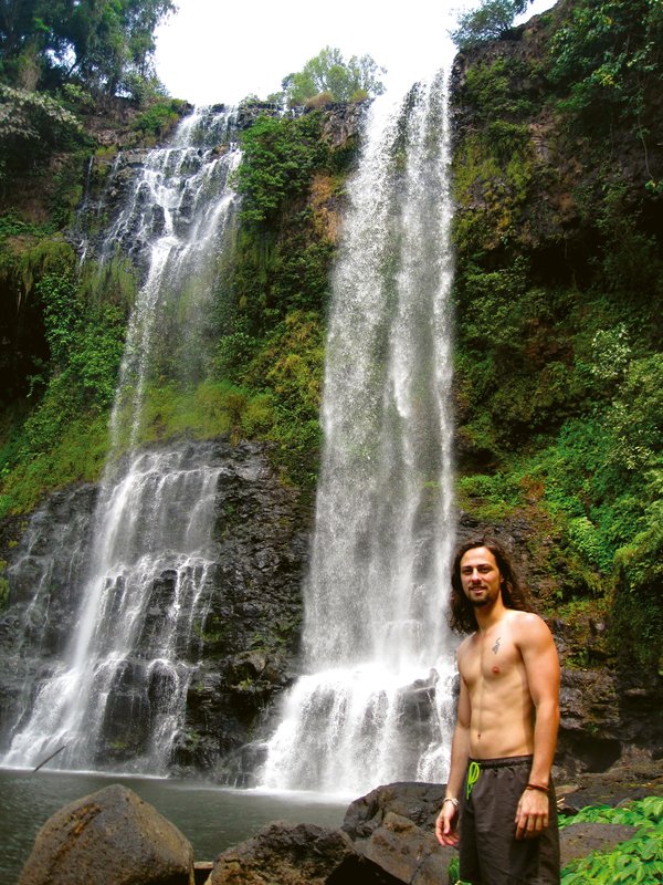 ragazzo in Asia posa davanti a una cascata