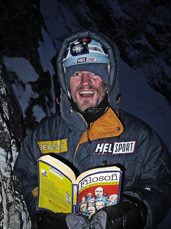 alpinista in bivacco con un libro