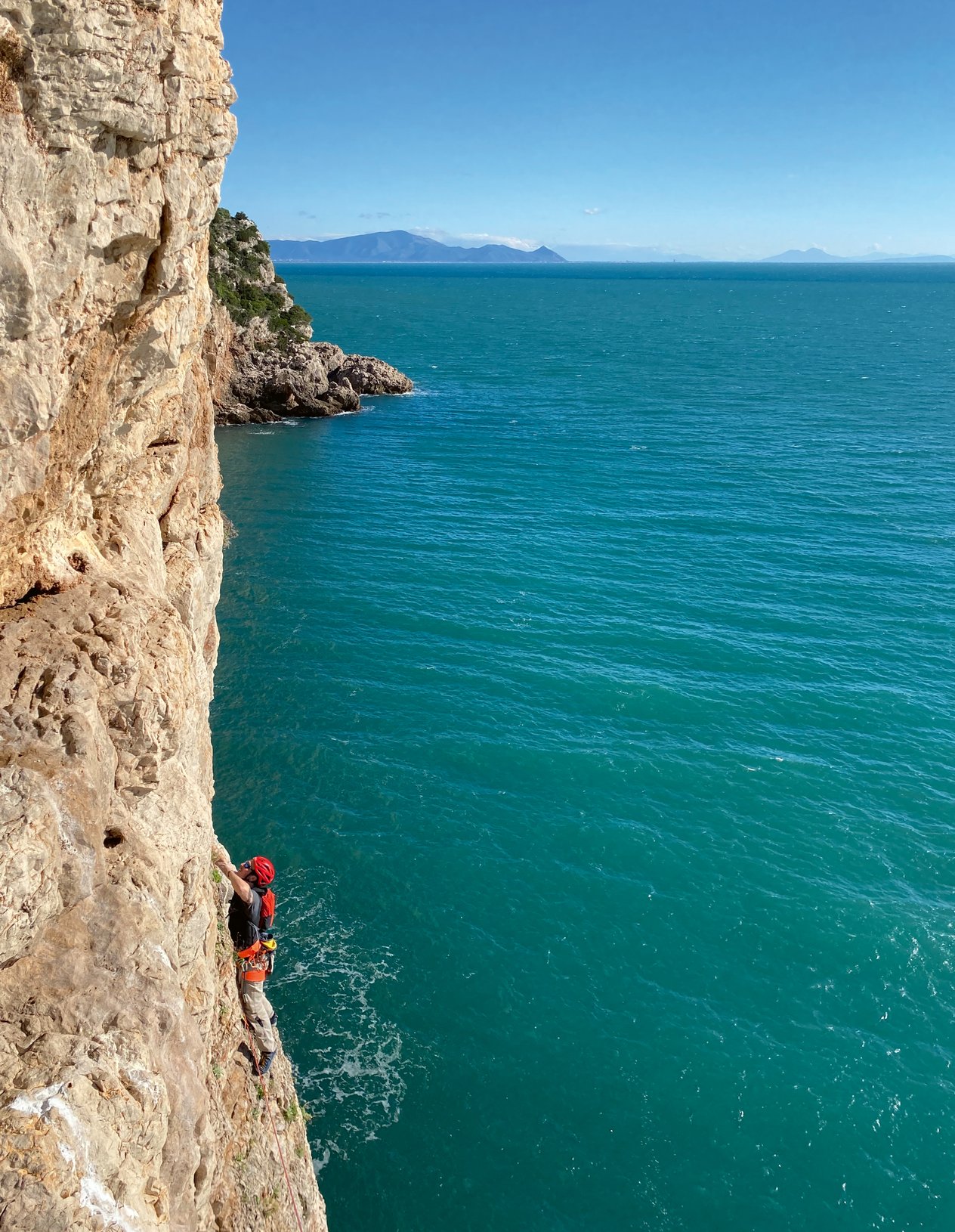 Climber in parete a picco sul mare