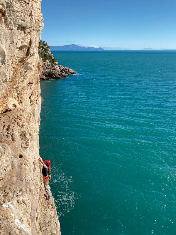 Climber in parete a picco sul mare